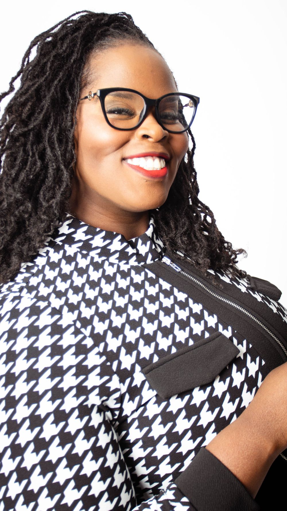 Studio portraits featuring black and white houndstooth pattern outfit with glasses.