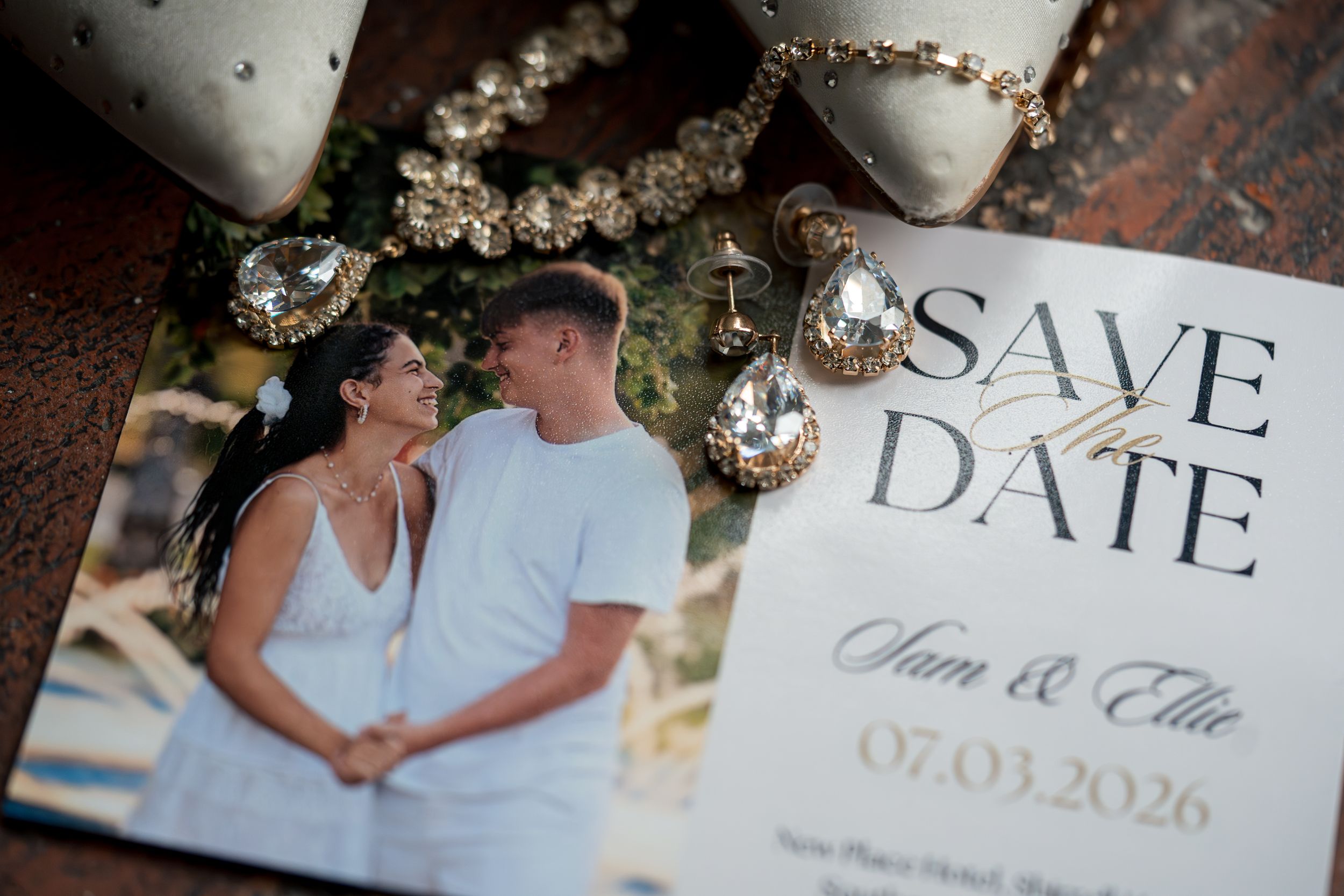 Save the date cards and wedding details photographed with sparkling decorative elements.