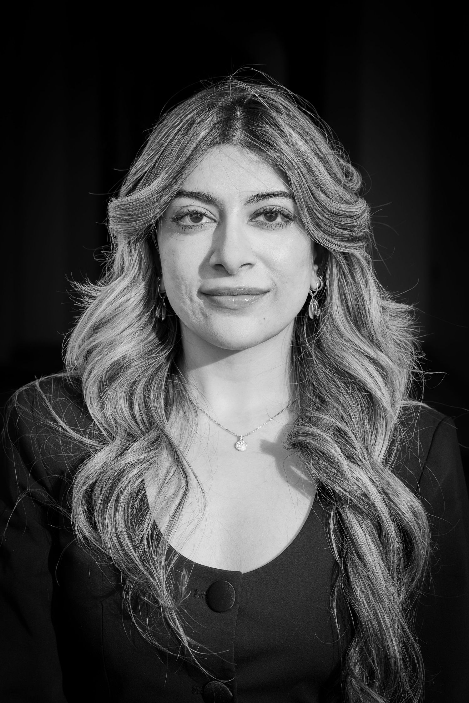 A black and white portrait series showing a woman with wavy blonde hair in a dark top against a dark background.