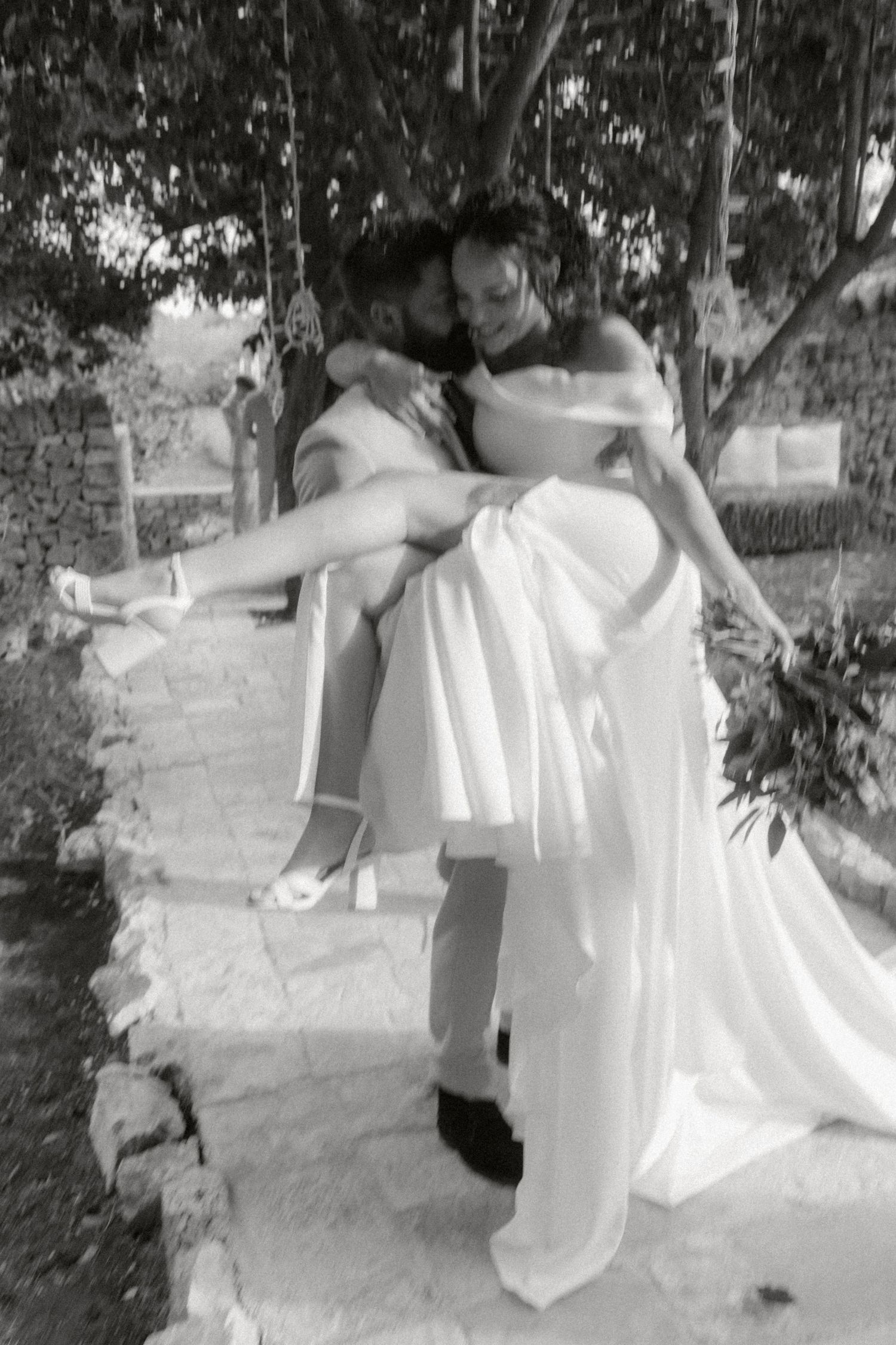 A sequence of black and white photos showing a couple in wedding attire dancing together outdoors.