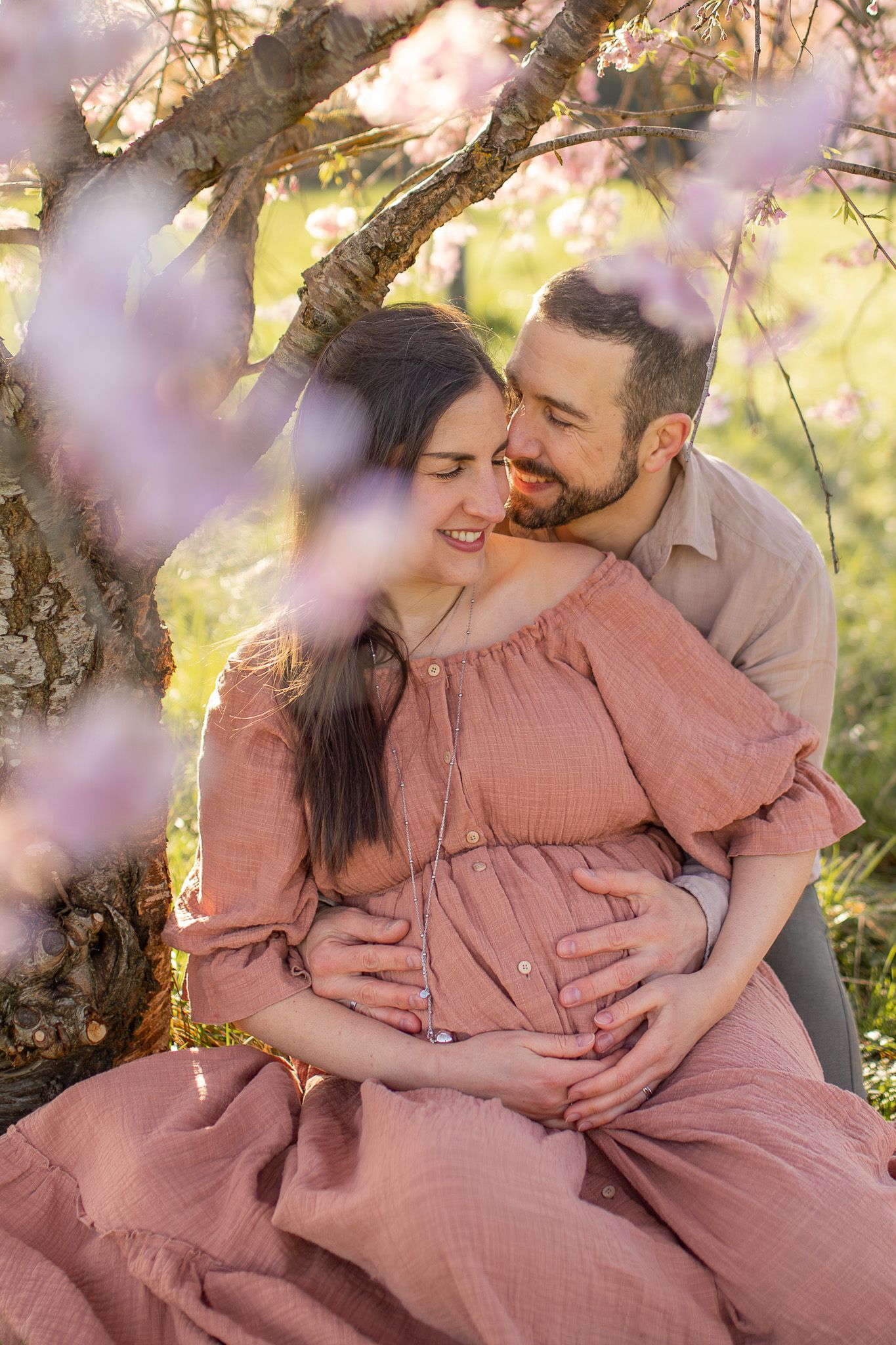 Couple attendant un bébé lors d’une séance photo grossesse, moment intime et complice en extérieur