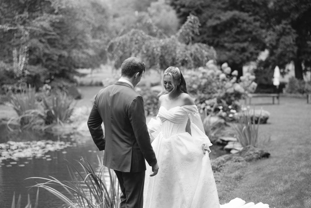 A romantic black and white wedding photo series showing a couple walking through a garden setting.