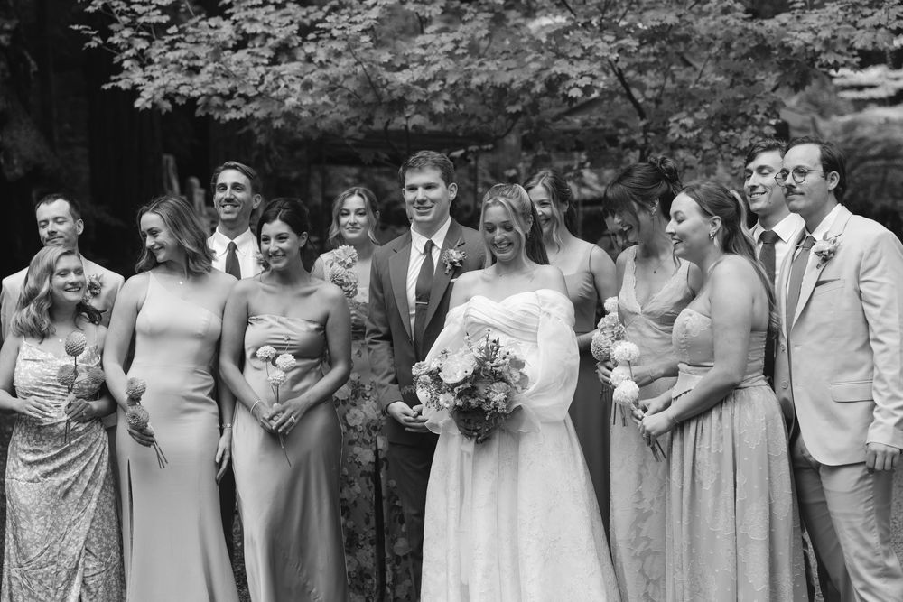 Wedding party poses together in black and white photo wearing coordinated formal attire.