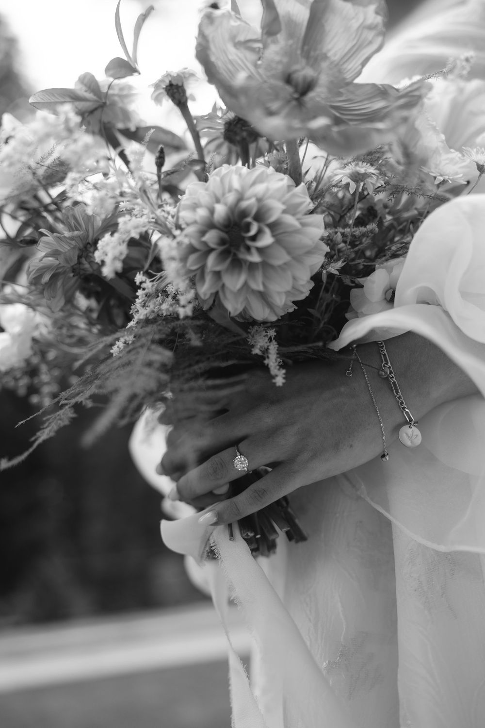 Close-up detail of a bridal bouquet with white and peach flowers adorned with delicate crystal accents.