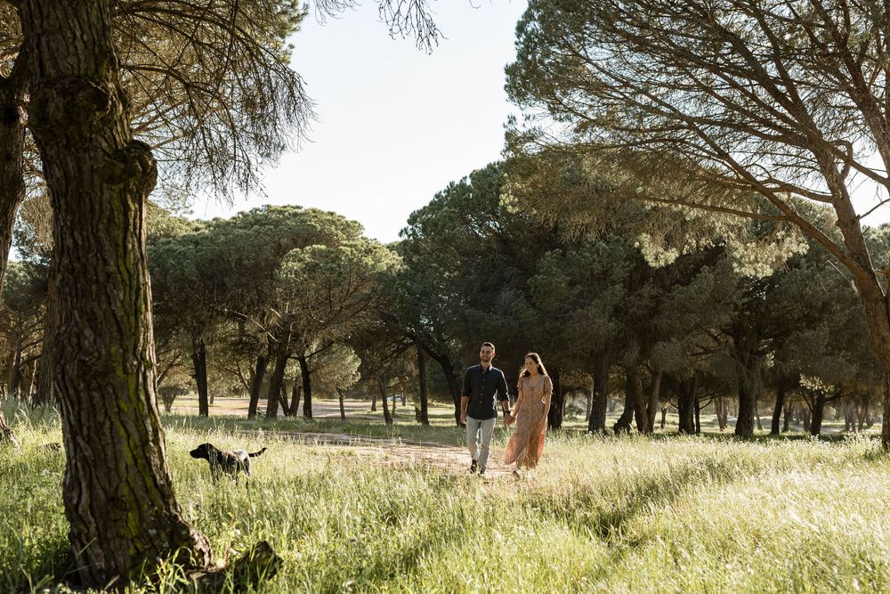 Romantic couple smiling and touching faces in golden hour light during pre wedding session in Sesimbra Portugal