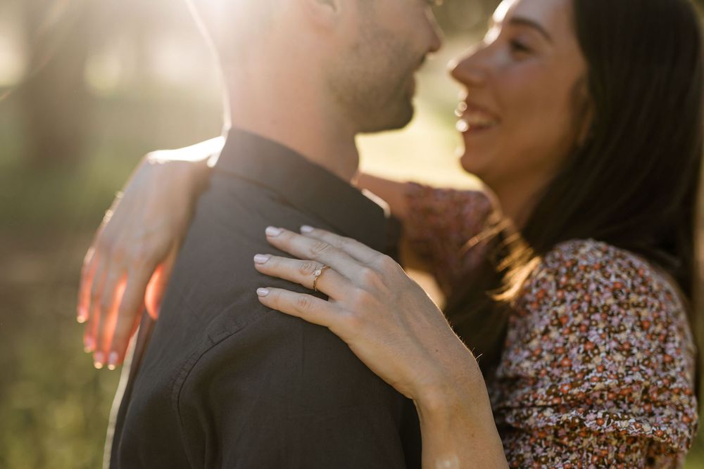 Backlit couple embracing with lens flare during sunset pre wedding photoshoot in Lagoa de Albufeira Portugal