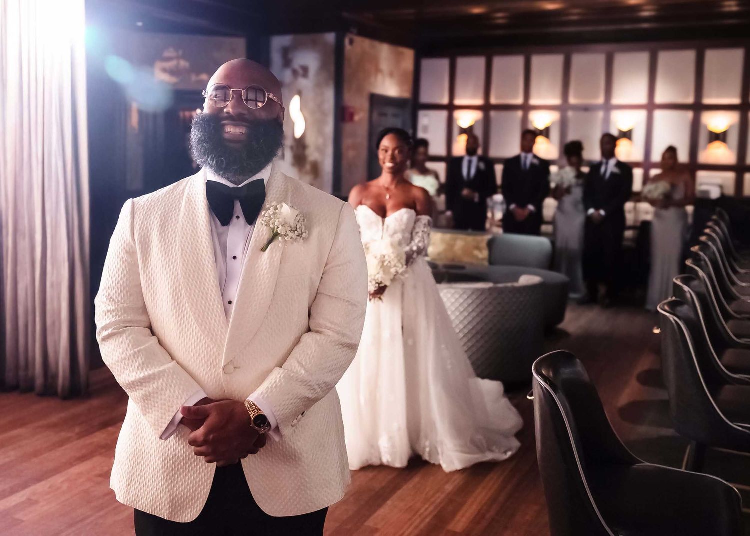 Groom smiling during first look in The Irving tavern at Lenox Hotel Boston with bride approaching in background