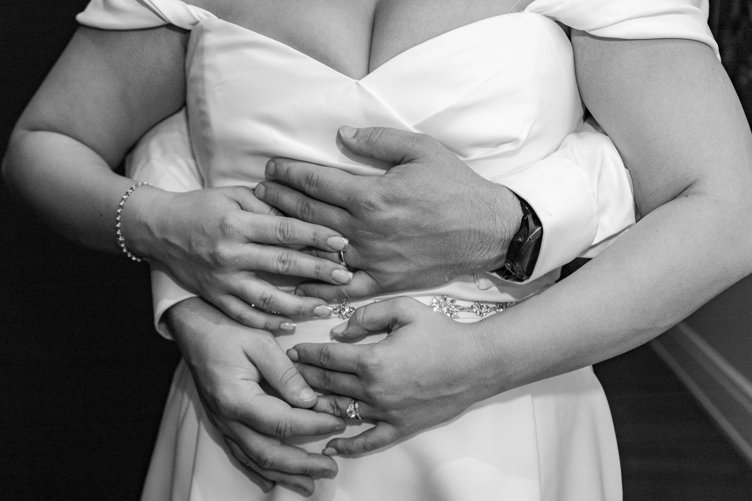 A black and white photo of a bride and groom dancing together during their first dance at a wedding reception.