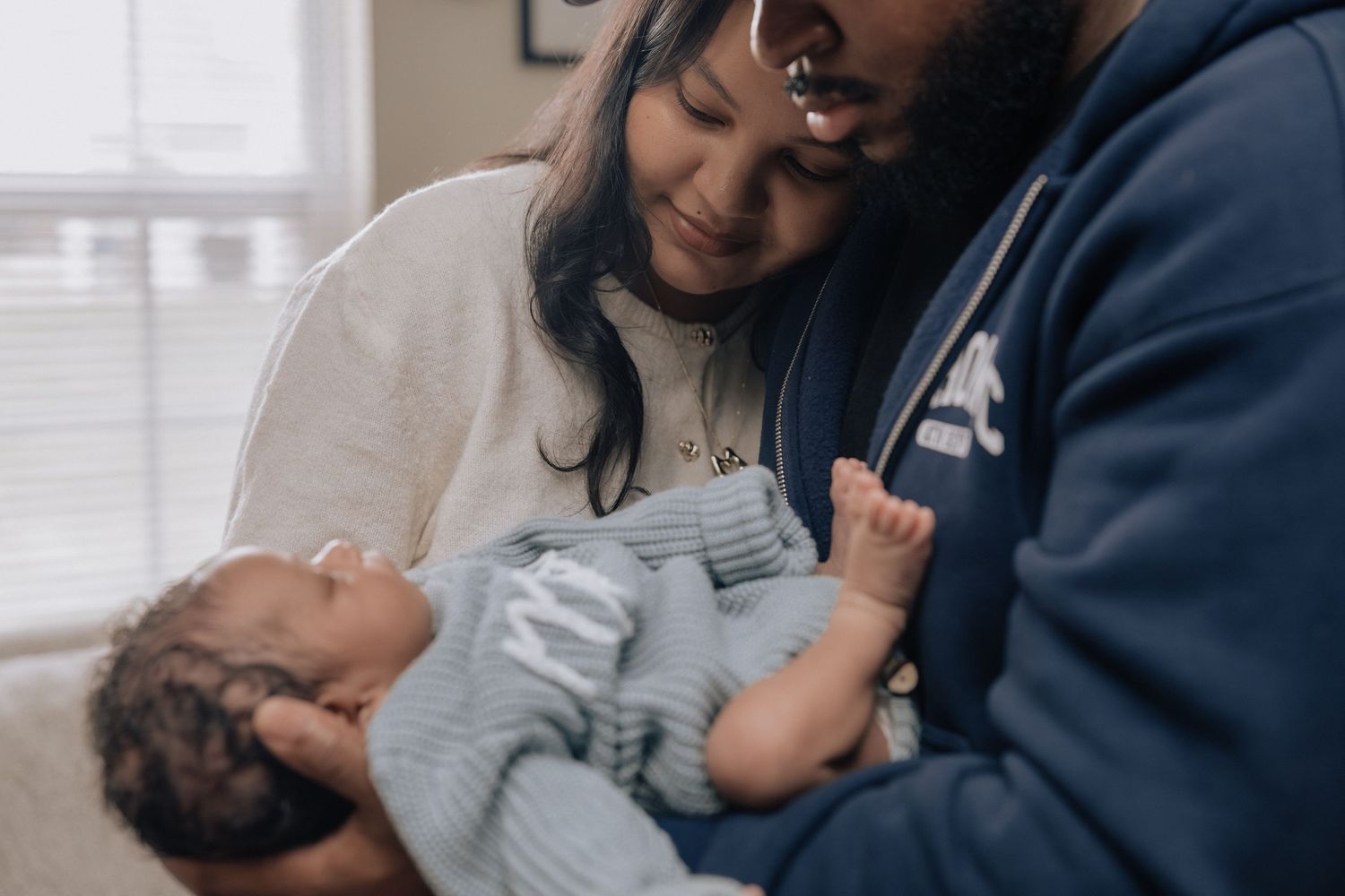 Parent and baby share tender moments together in a series of heartwarming black and white photographs.