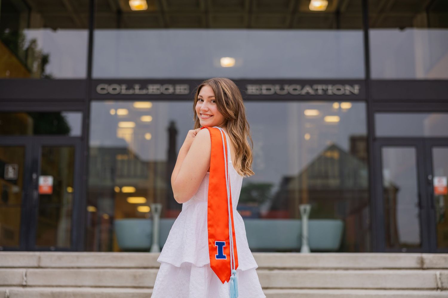 UIUC student holding stole over her shoulder in front of the College of Education