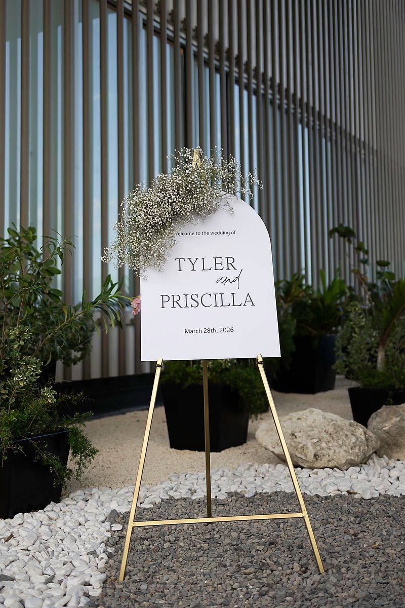 Wedding welcome sign for Tyler and Priscilla on March 29th, 2026, displayed on a gold easel with floral decor.
