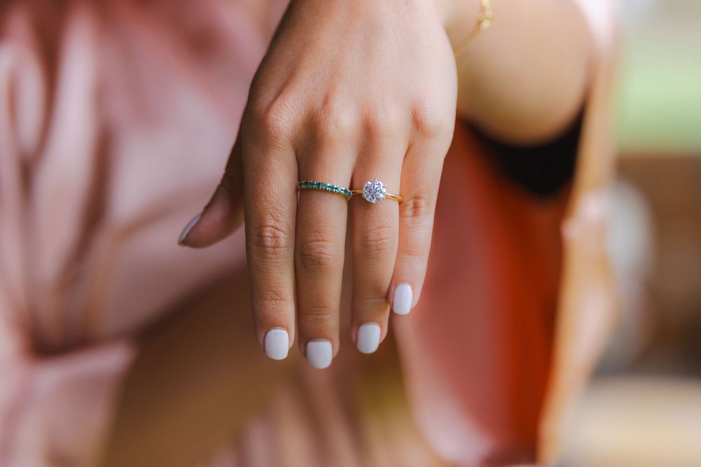 A close-up view of a person's hand wearing a ring on their finger.