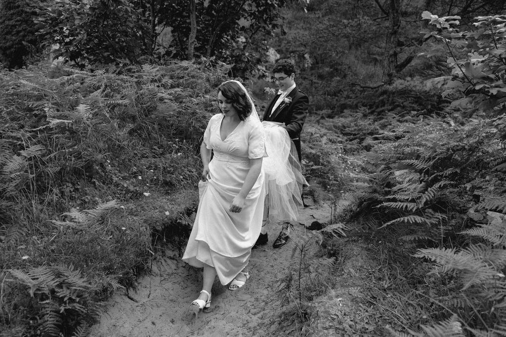 A series of black and white photographs showing a person in white dress walking through a wooded forest path.