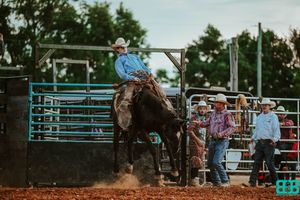 Intense rodeo competition taking place in an outdoor arena during daytime.