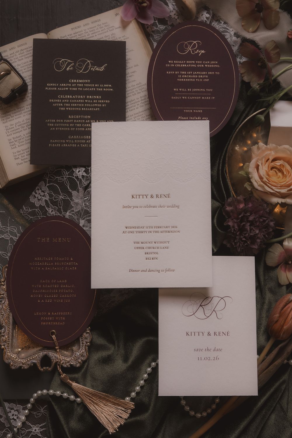 Elegant wedding invitation suite featuring burgundy and white stationery with pearl accents and floral details.