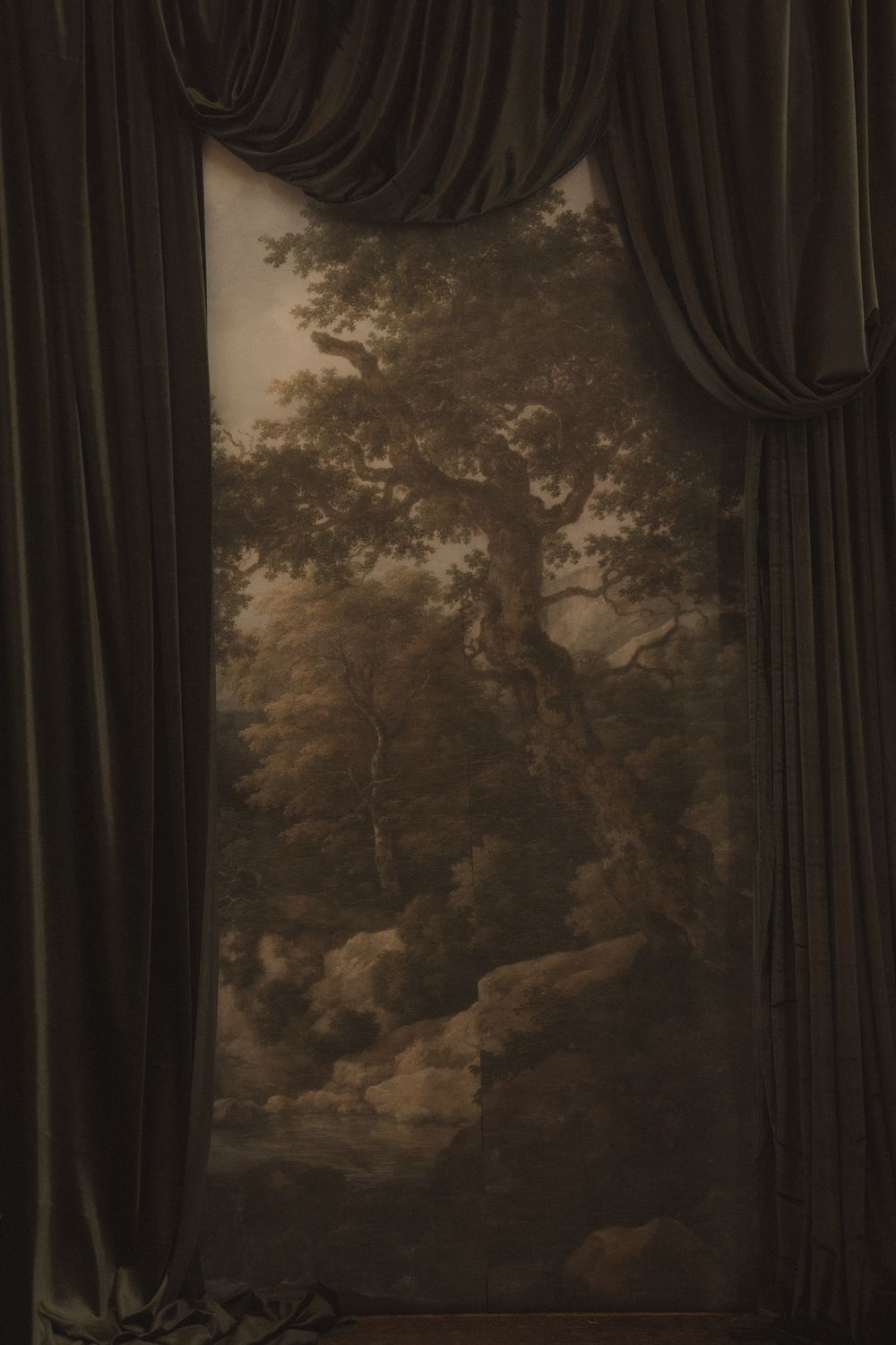 Dark curtains frame a moody landscape mural or painting with trees and atmospheric lighting.