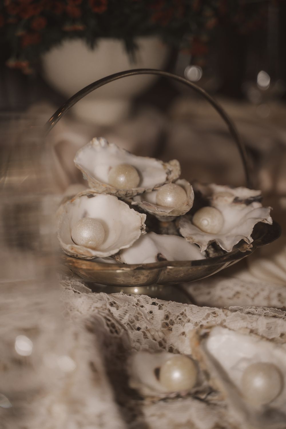Fresh oysters on the half shell arranged on a metal serving dish in moody sepia tones.