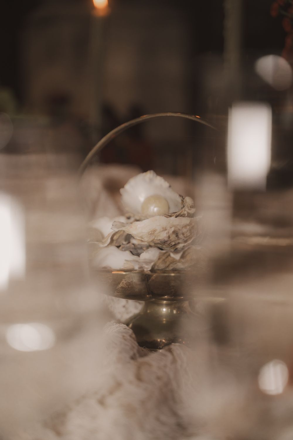 Sepia toned close-up photograph of small decorative glass vessels arranged on a table with soft bokeh lighting effects.