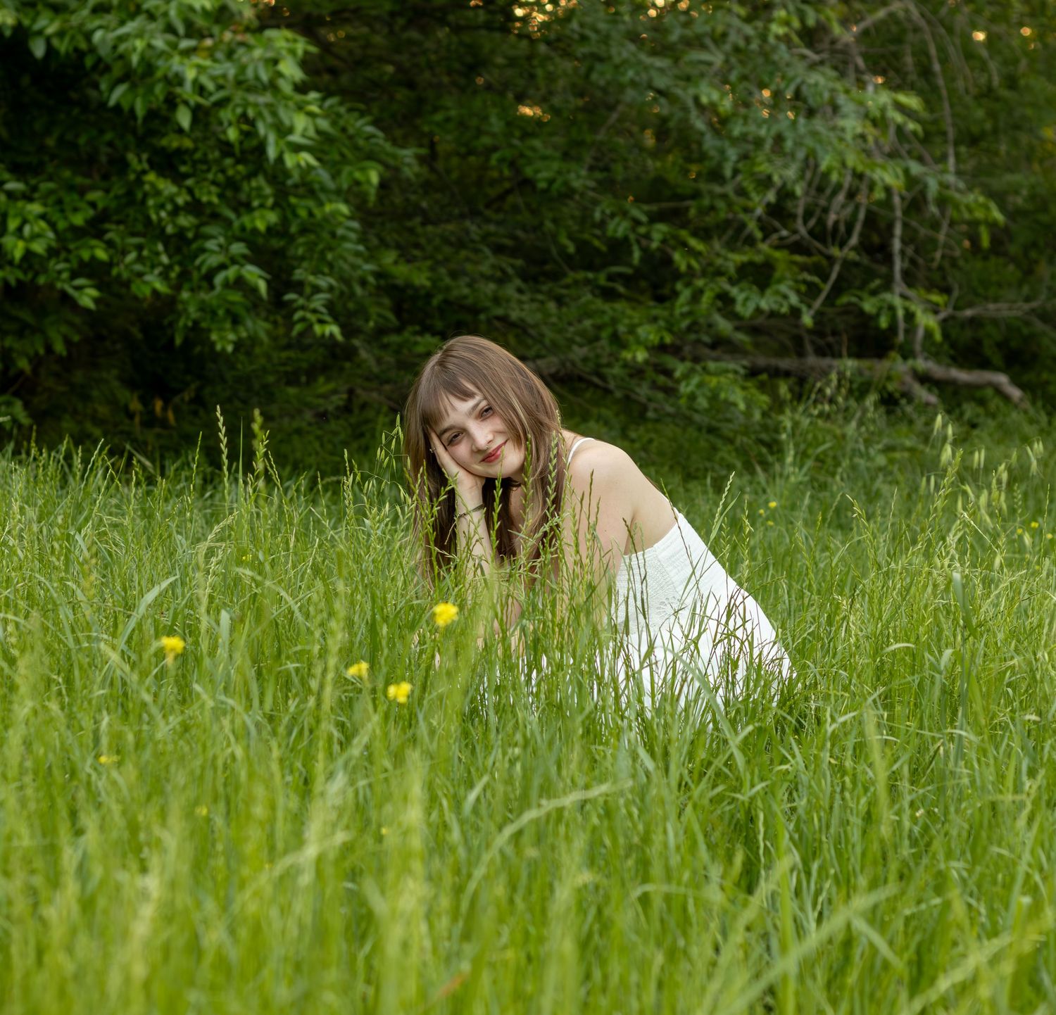 A person in a white dress sits peacefully in a lush green meadow with yellow wildflowers on a sunny day. Airfield falls fort worth tx