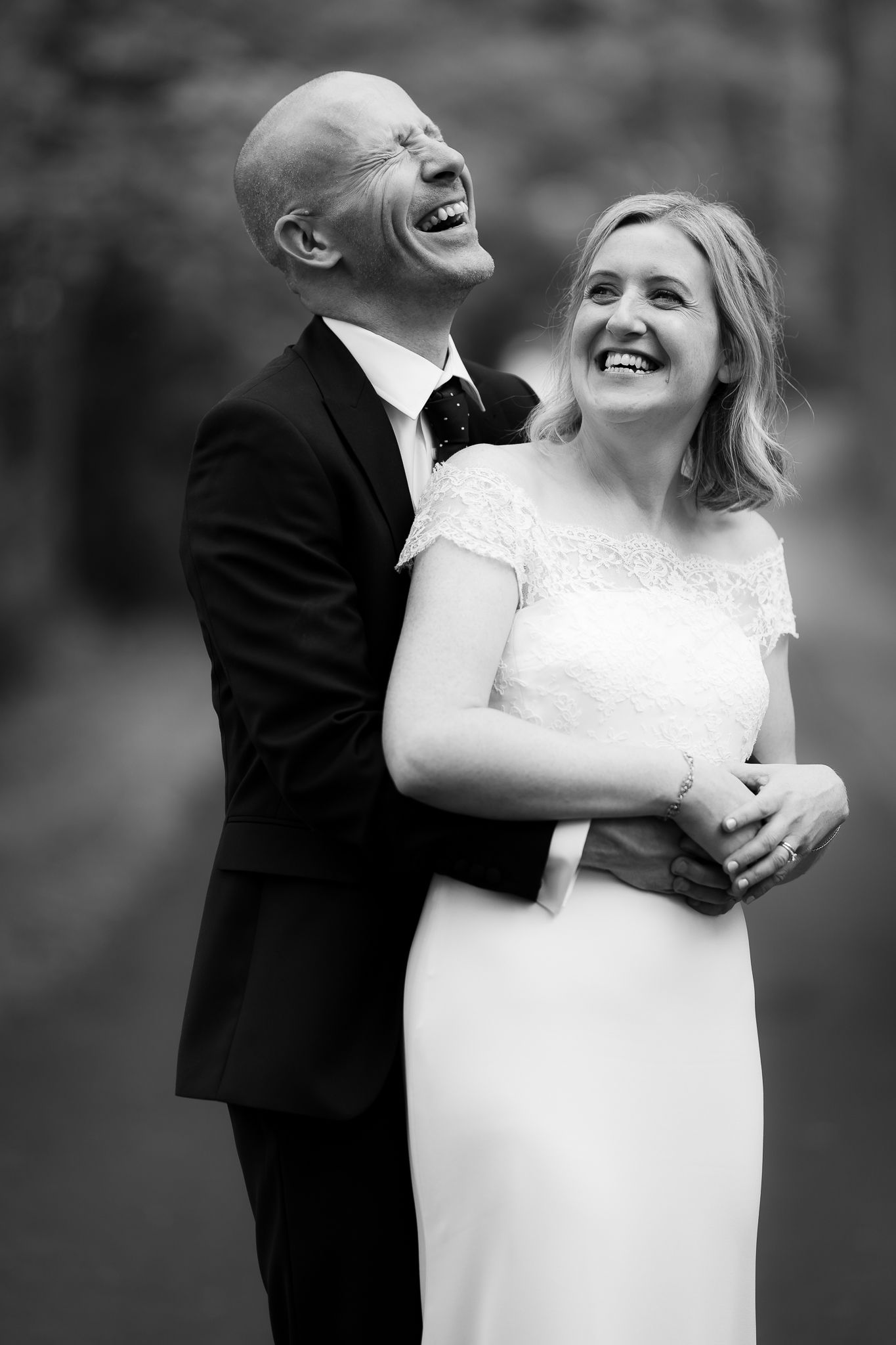 Black and white portrait of newlyweds sharing a joyful moment together. Woodhill Hall.