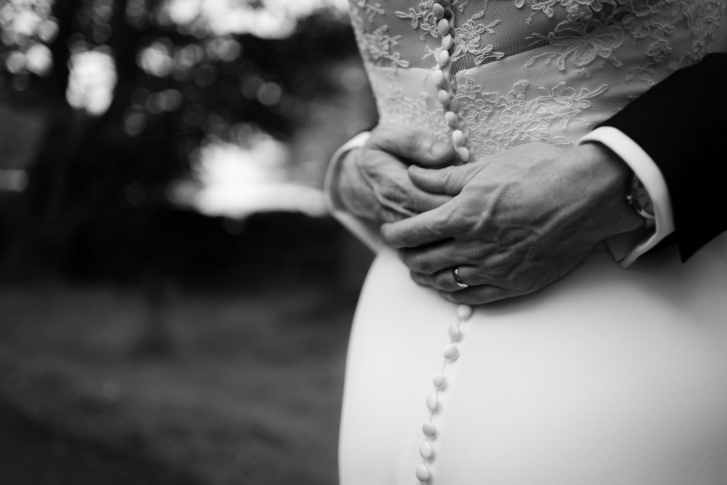 Close-up detail of wedding dress buttons in black and white photography. Woodhill Hall.
