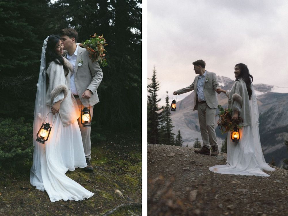 bride and groom walk through the forest at dawn with old fashioned lanterns during their Banff elopement