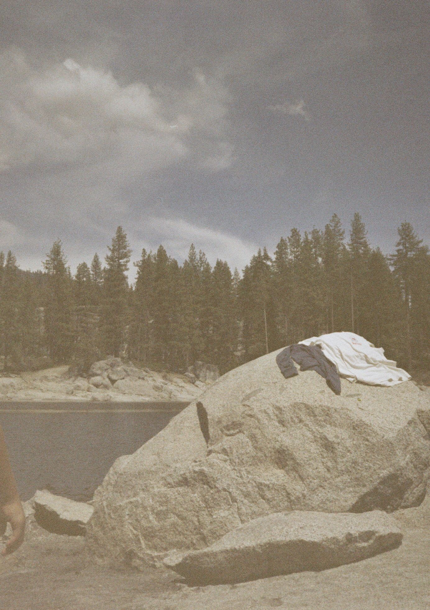 Large gray boulders and rock formations scattered along a forested landscape under an overcast sky.