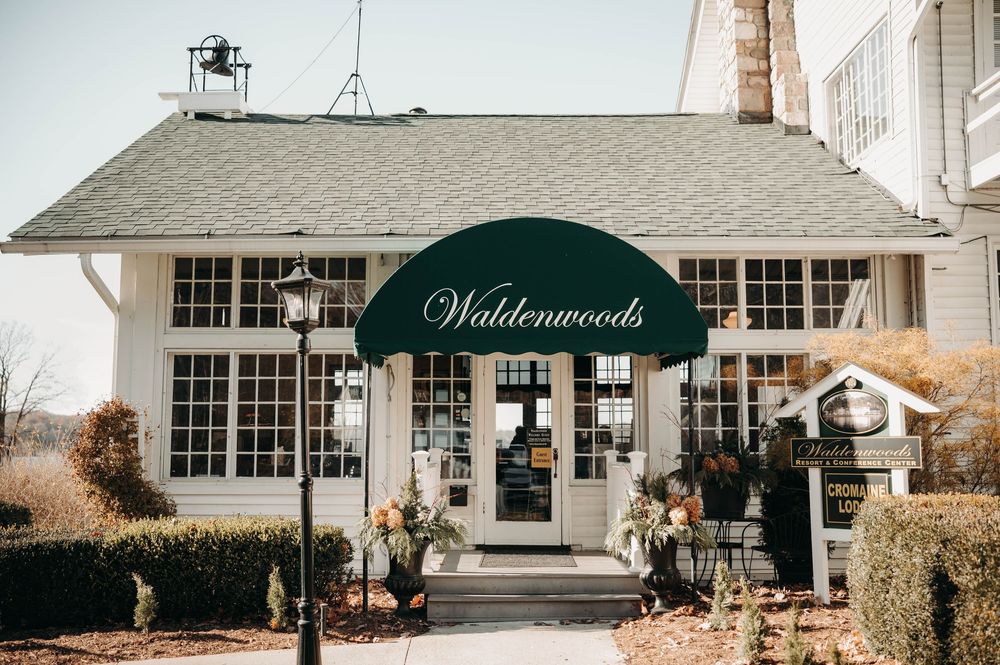Exterior of Waldenwoods wedding venue featuring a green awning entrance surrounded by manicured landscaping.