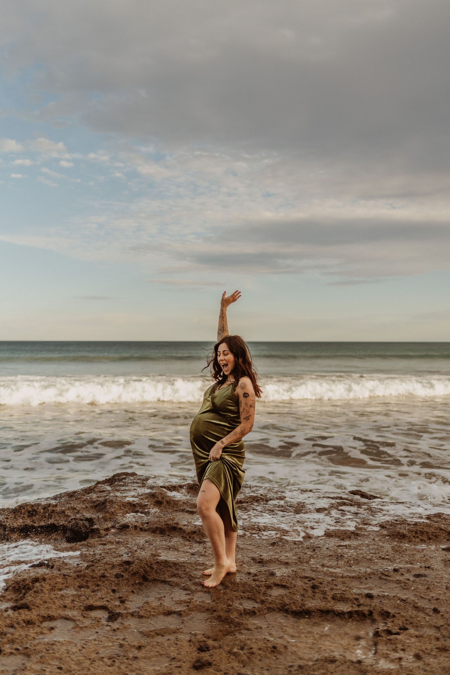 Green velvet dress photographed on maternity model at the beach