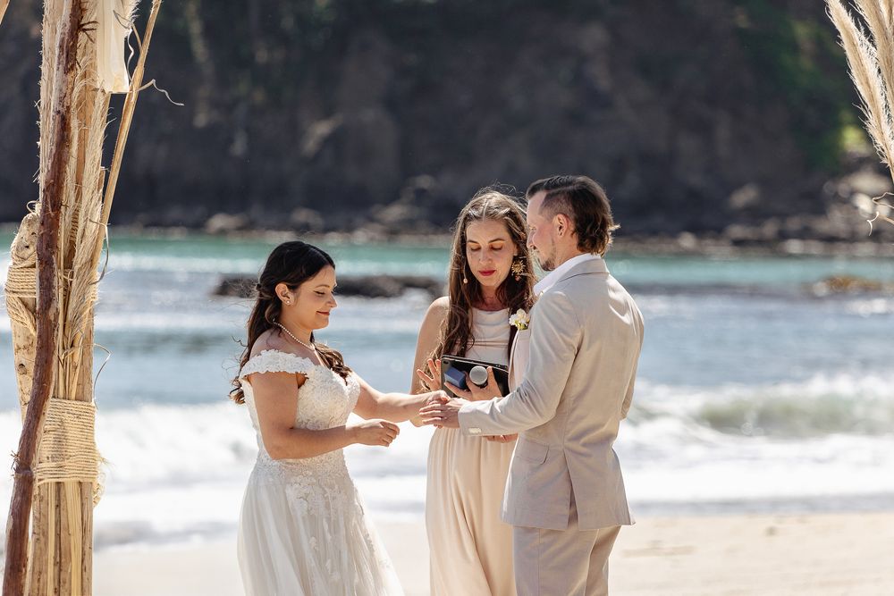 Intimate beach wedding ceremony with waves crashing in the background.