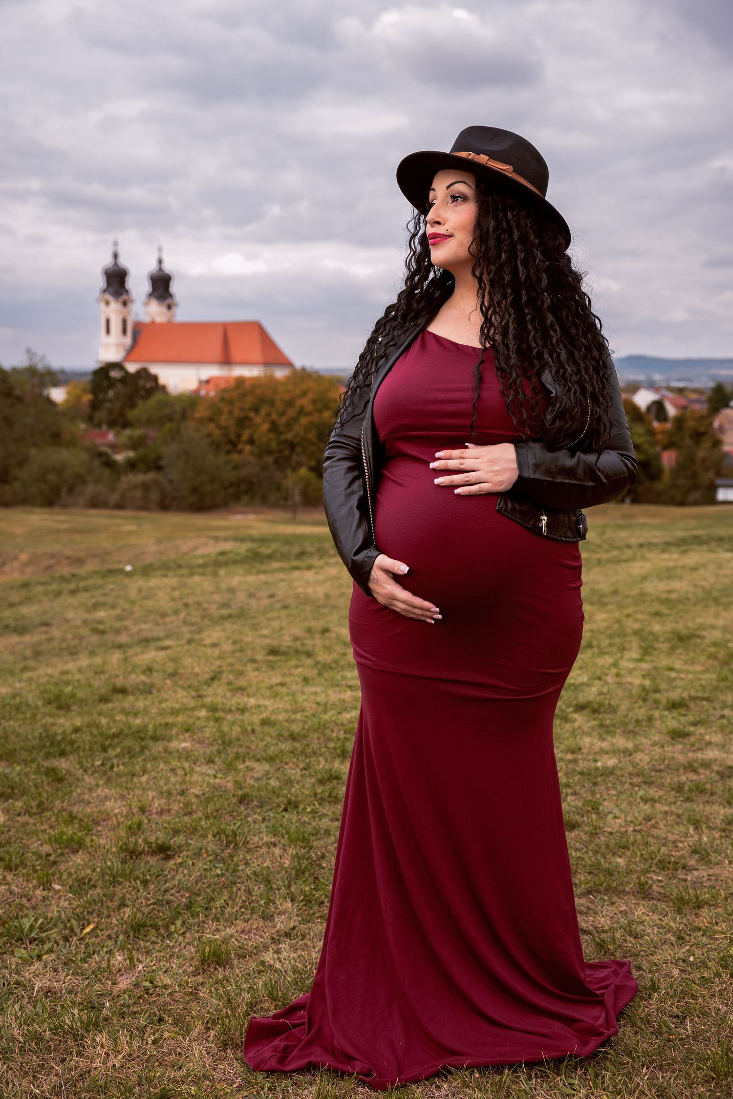 kismama a hasát fogva mosolyog tatán a kálvária dombon