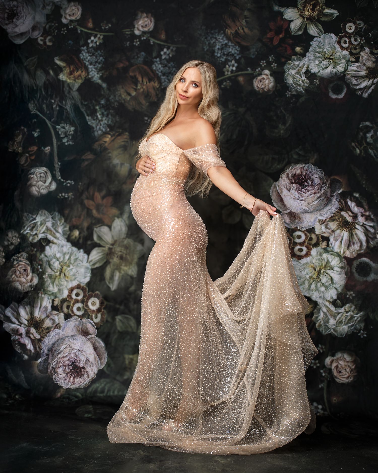 Dark floral backdrop example available to clients at Sydney photography studio. Stunning pregnant woman swishes glam gown.