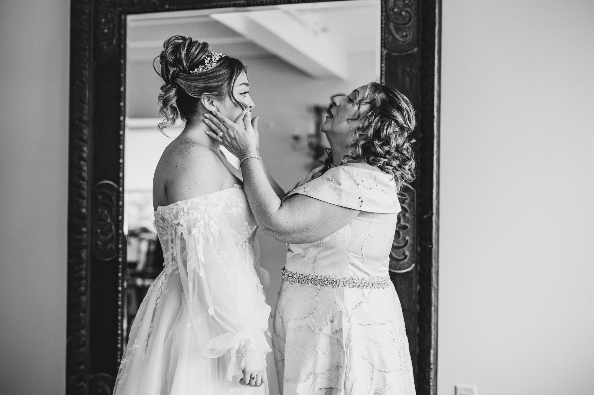 Emotional moment captured in black and white as wedding party shares embraces.