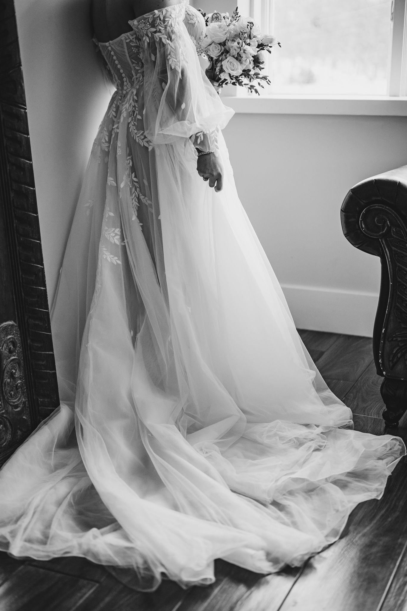 Dramatic black and white shots of flowing wedding dress train near window.