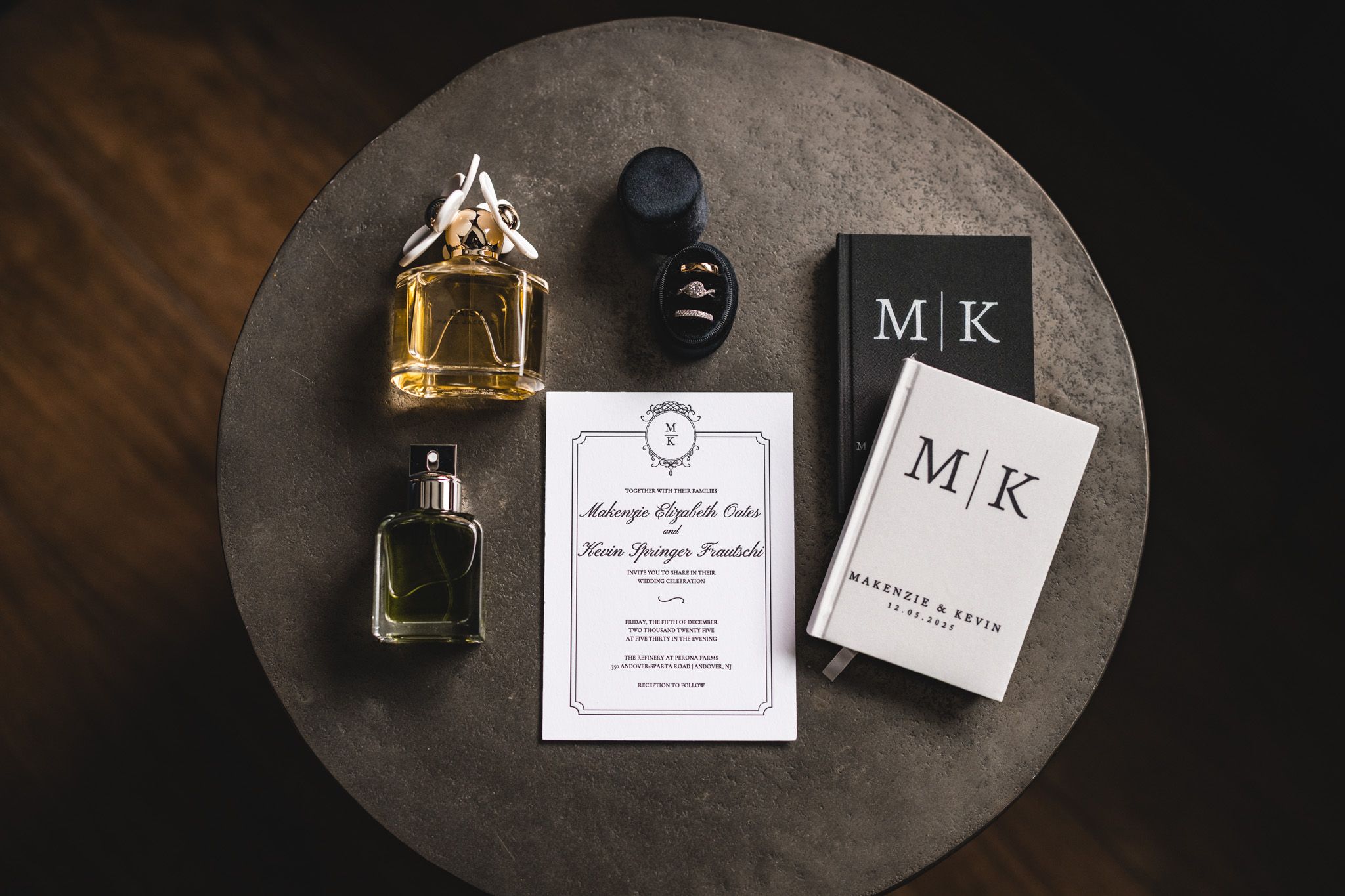 Wedding stationery and accessories arranged on round table with perfume bottles.