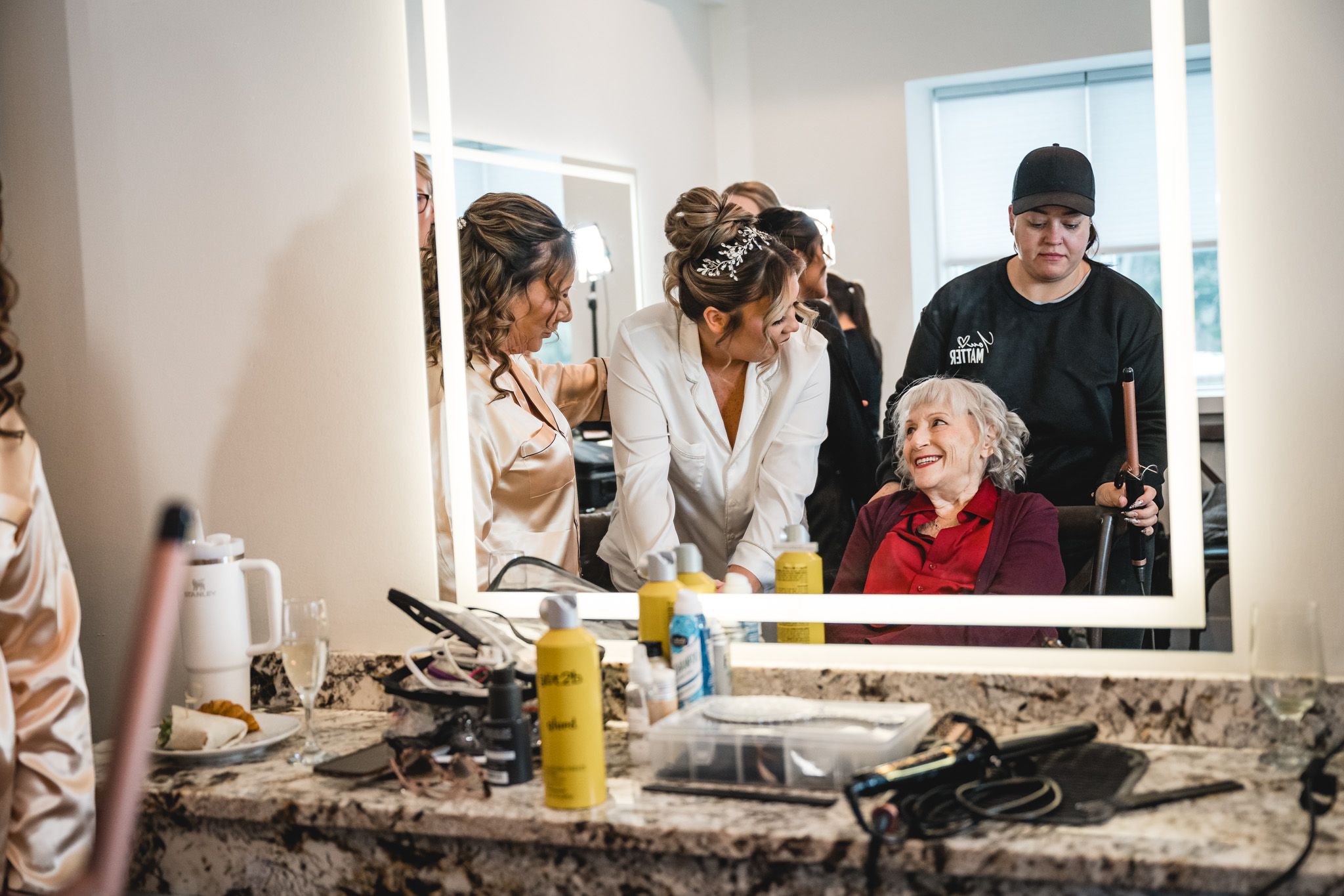 Getting ready scene in bridal suite with mirrors and beauty products.