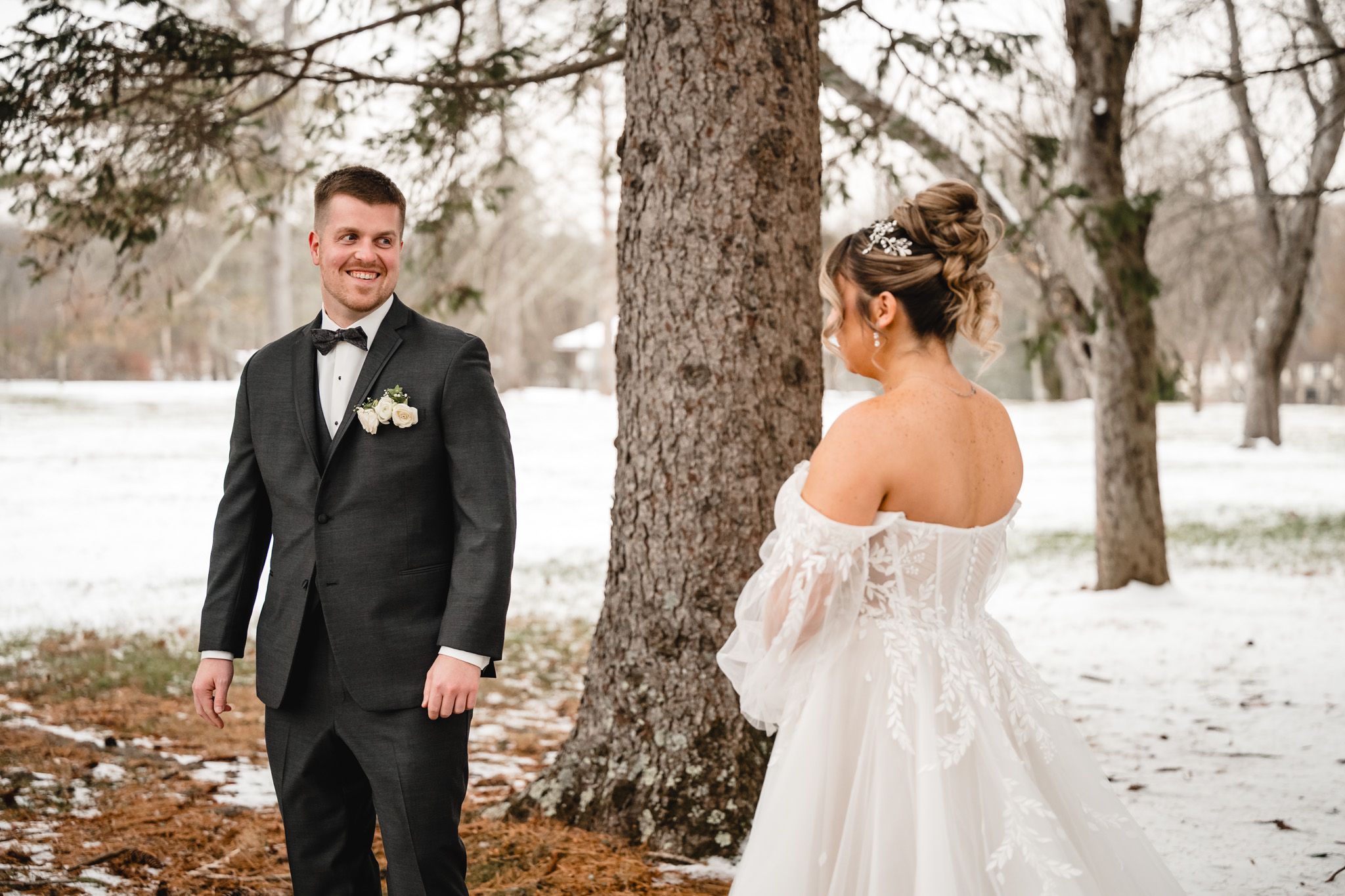 Bride and groom share intimate moment in snowy winter forest setting.