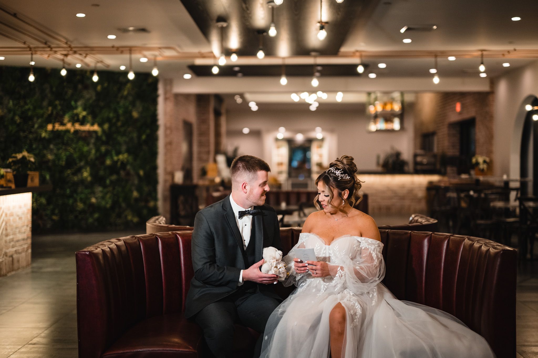 An intimate wedding moment captured in a modern restaurant setting with warm lighting.