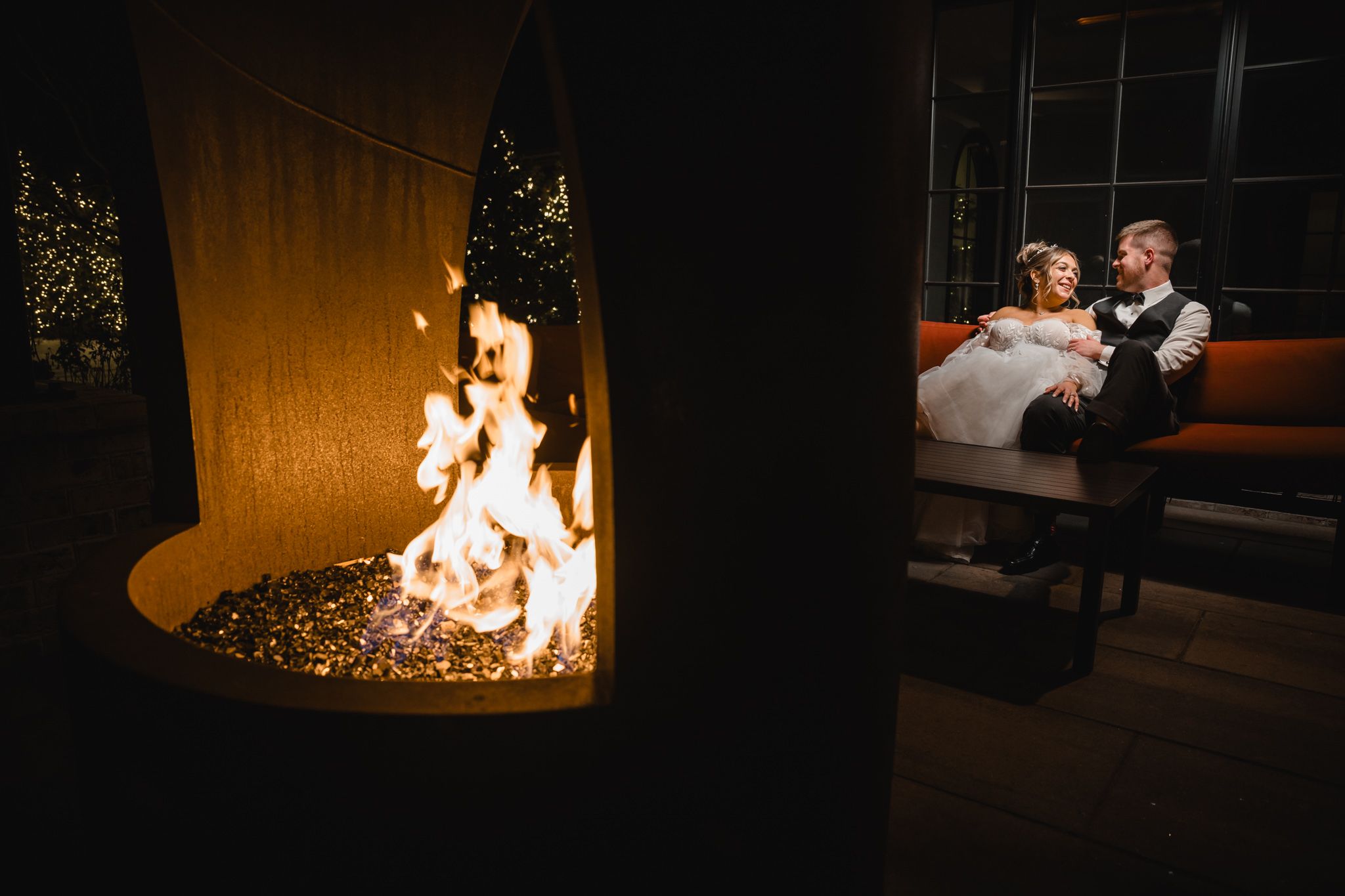 A cozy wedding scene with a warm fireplace glowing in the foreground.