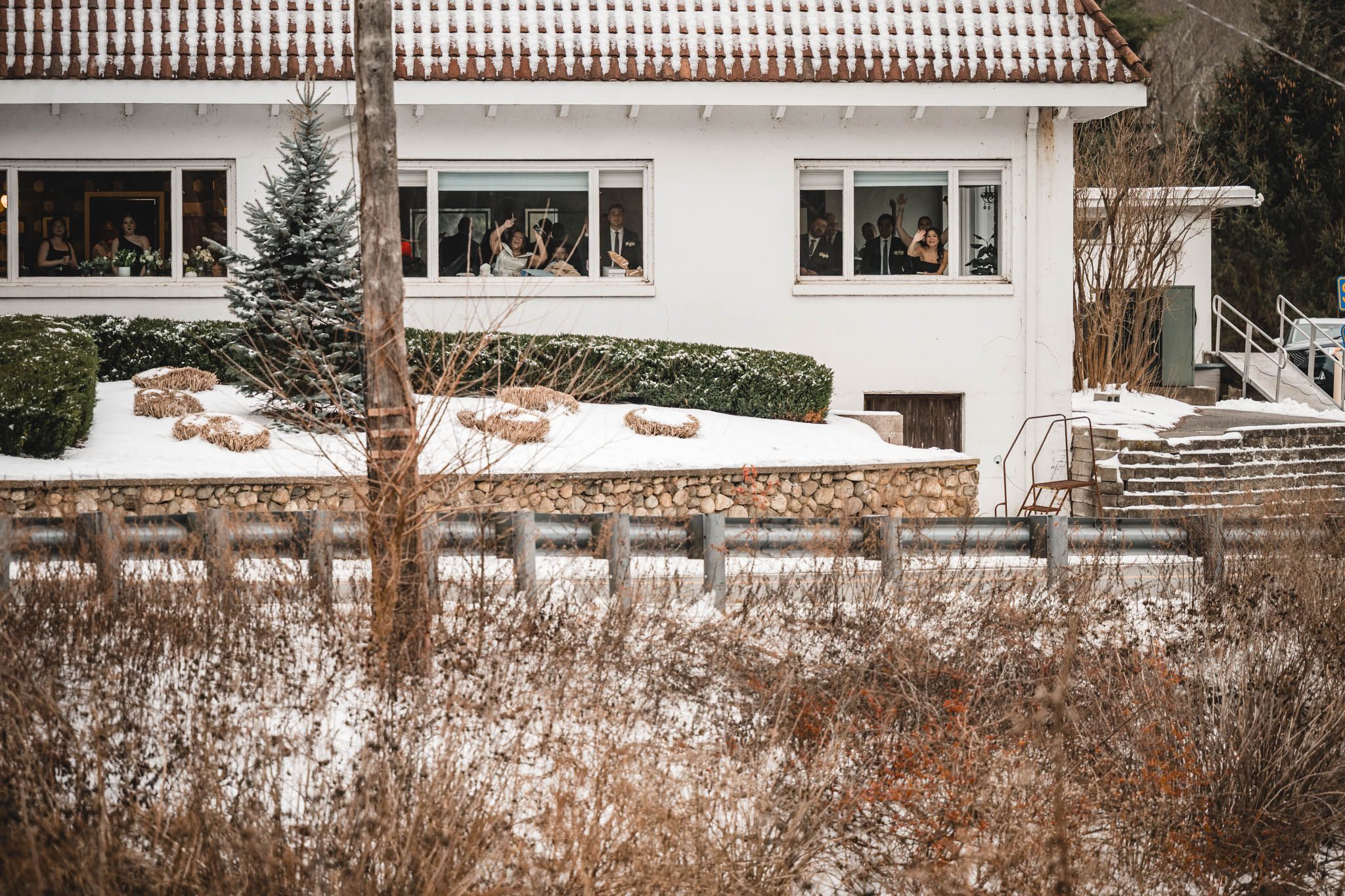 White modern building with wooden fence visible in snowy winter landscape.