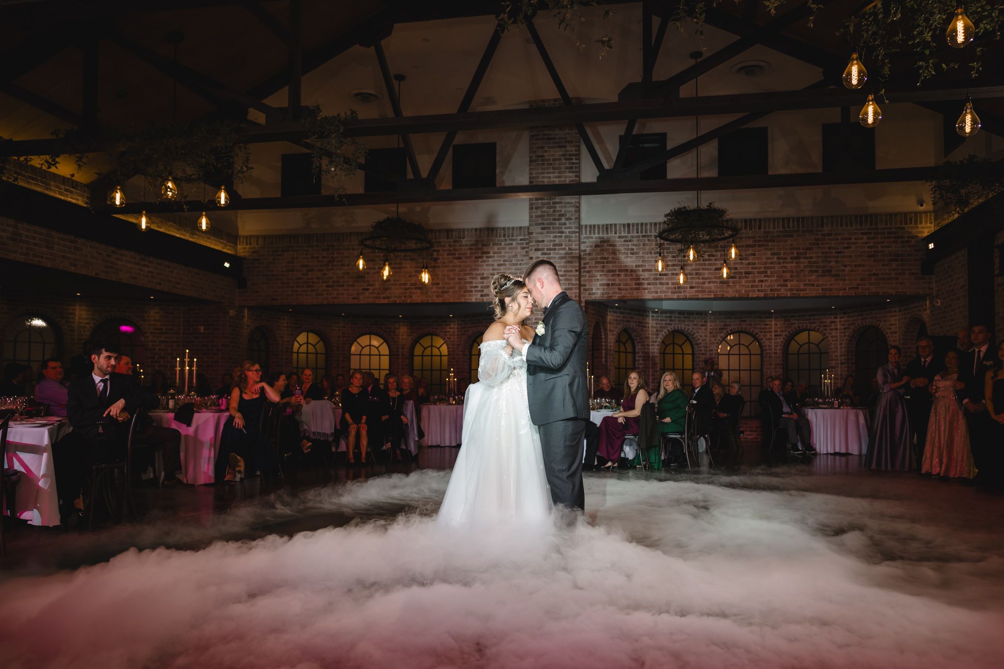 Wedding dance floor filled with fog effects and ambient lighting during a reception.