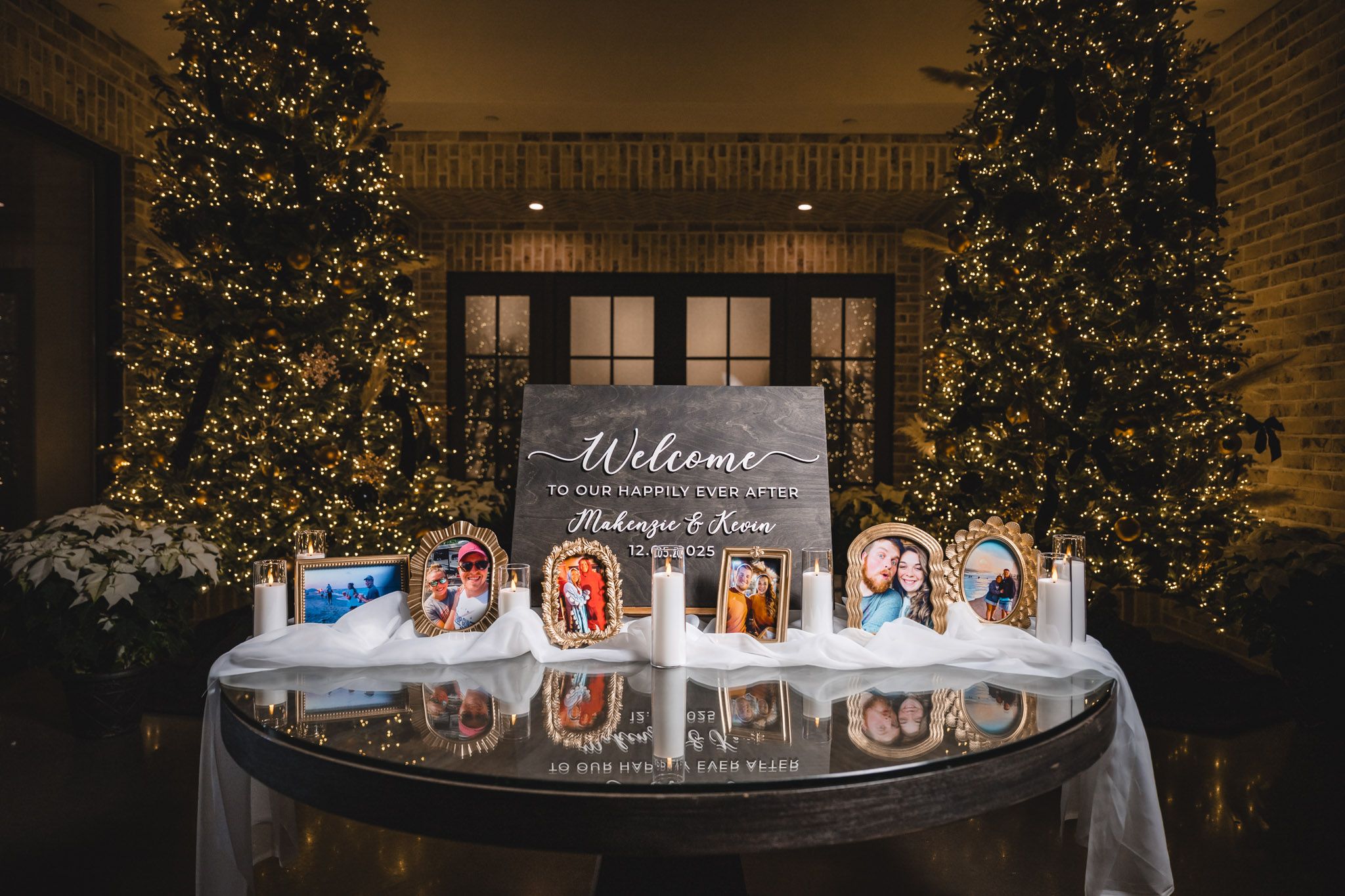 Wedding welcome sign display with decorative lighting and greenery in an outdoor setting.