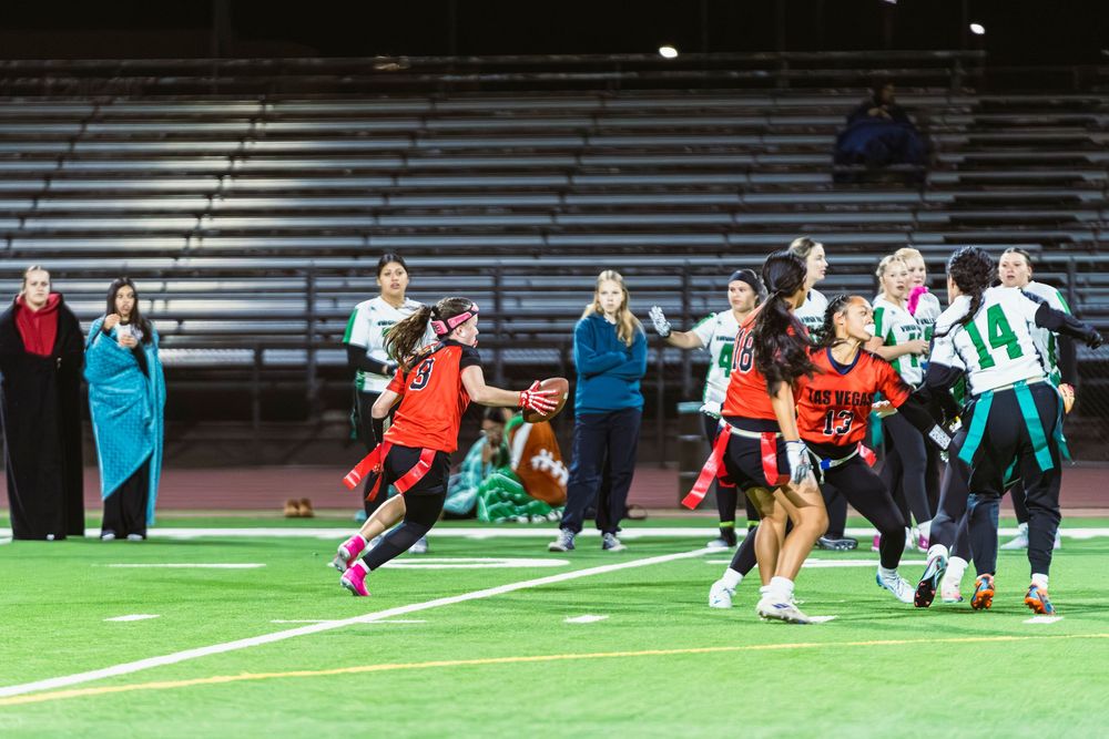 Girls flag football player running off field with the ball