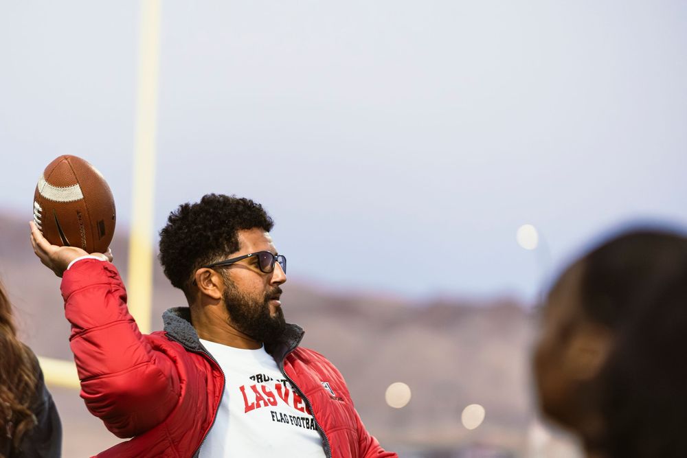 Girls flag football coach throwing the football