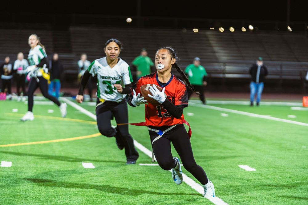 Girls flag football player running with the ball
