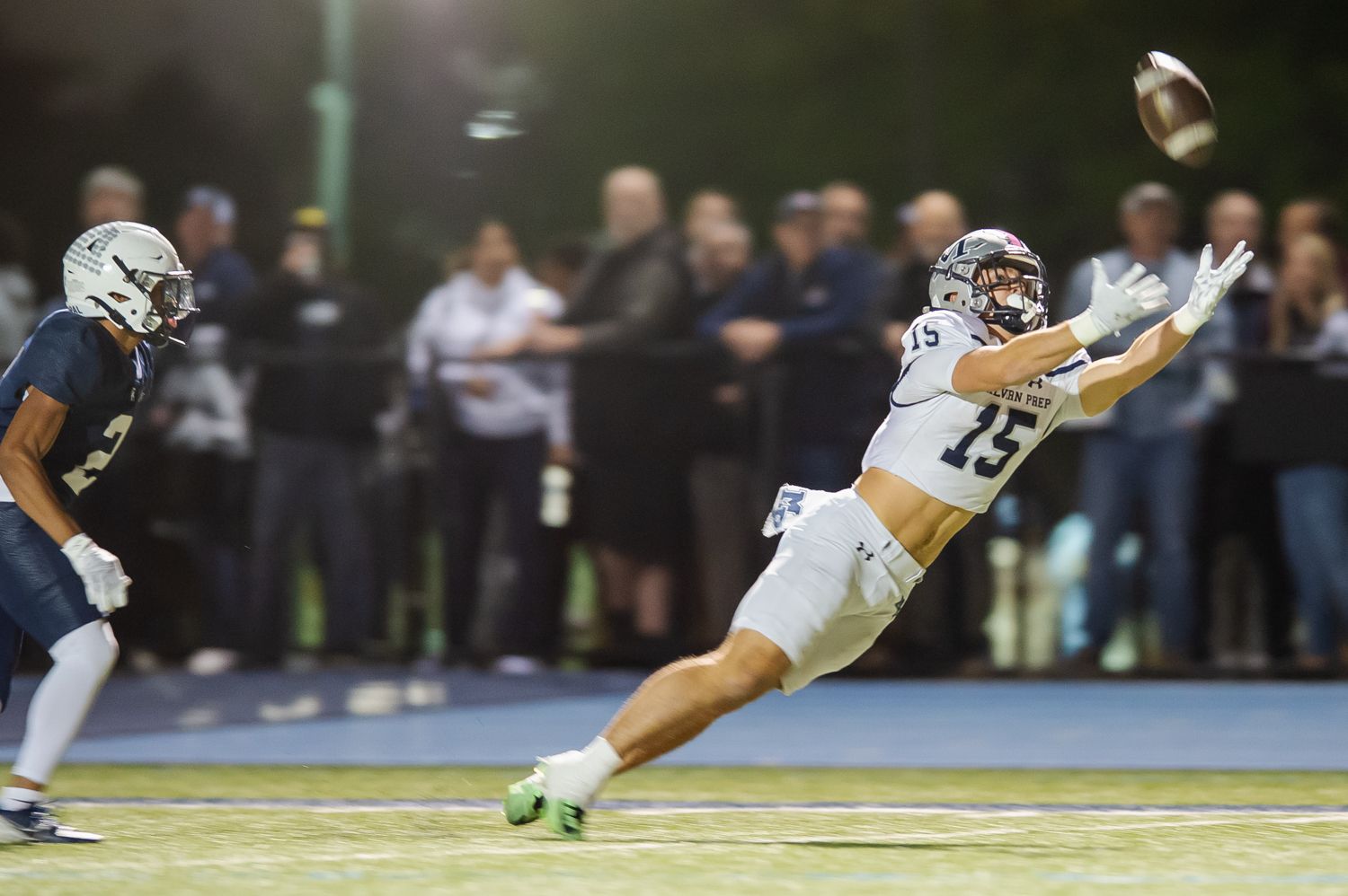 Malvern Prep high school football player dives to catch a football in a game.
