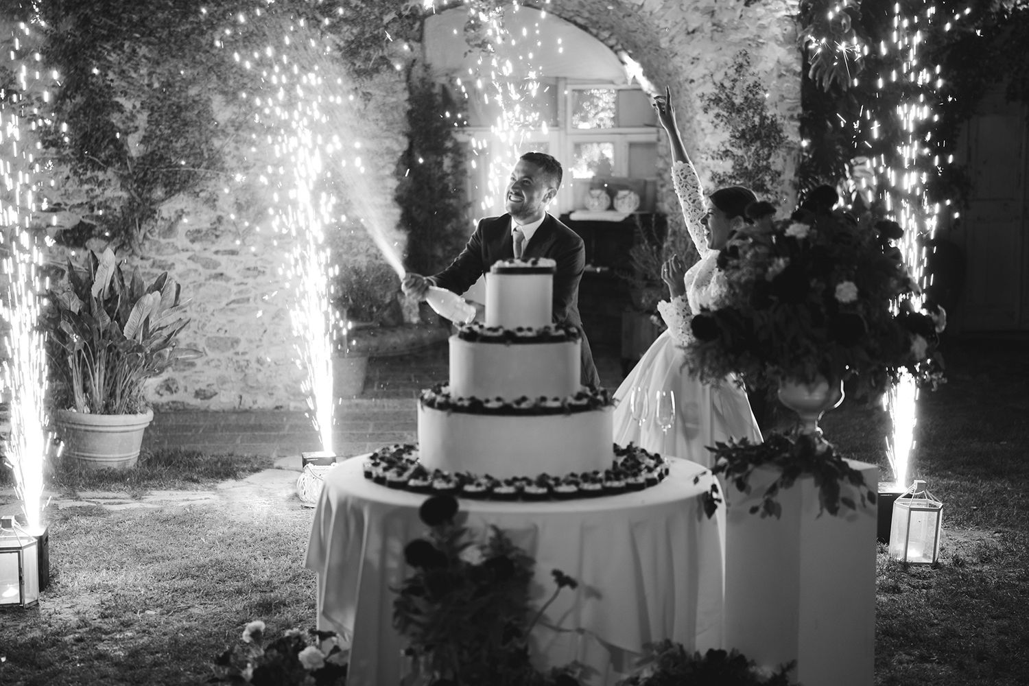 Taglio della torta con sparkular durante un matrimonio serale in Liguria
