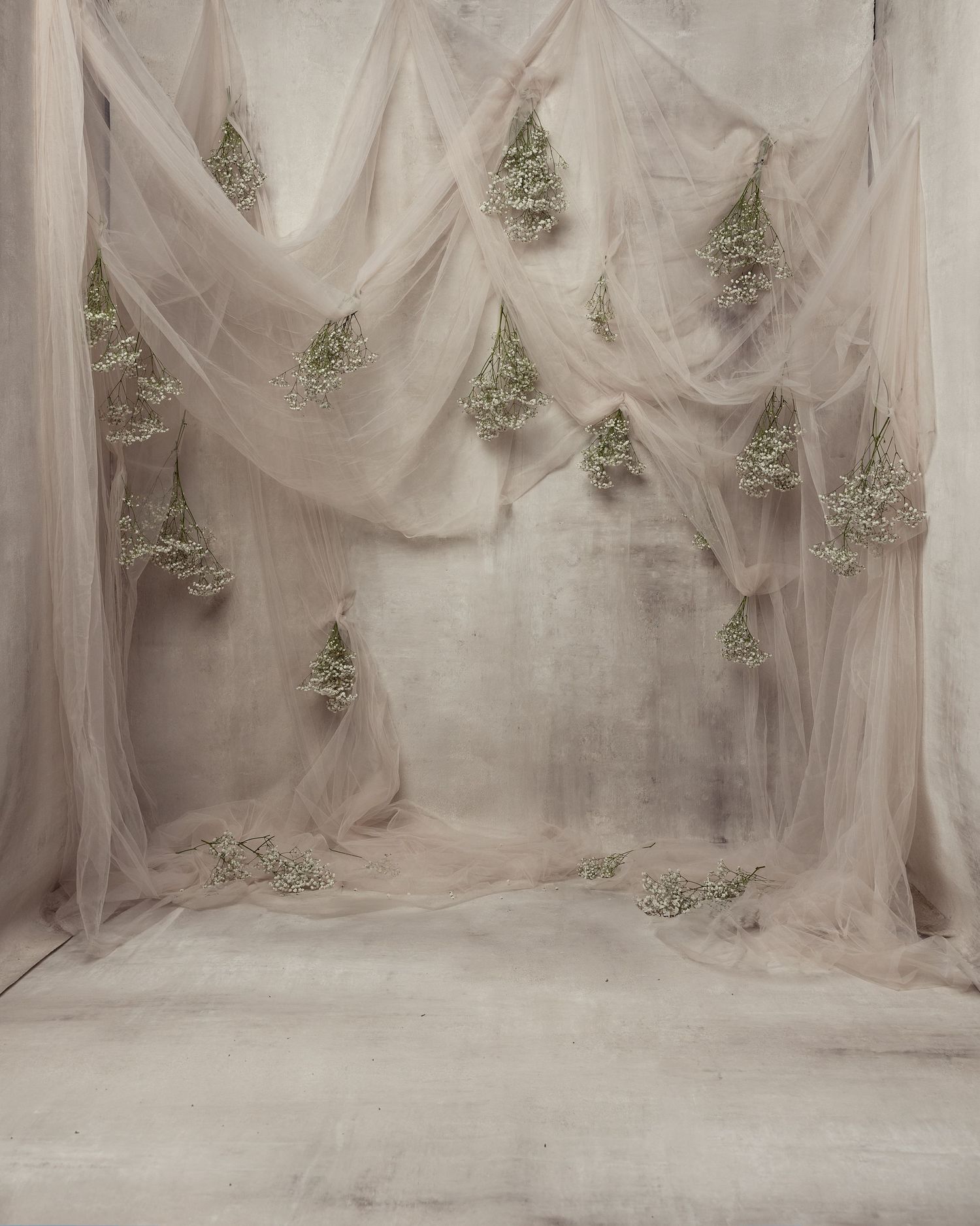 Ethereal studio backdrop with sheer white fabric draping and small silver Christmas trees creating a dreamy winter scene.