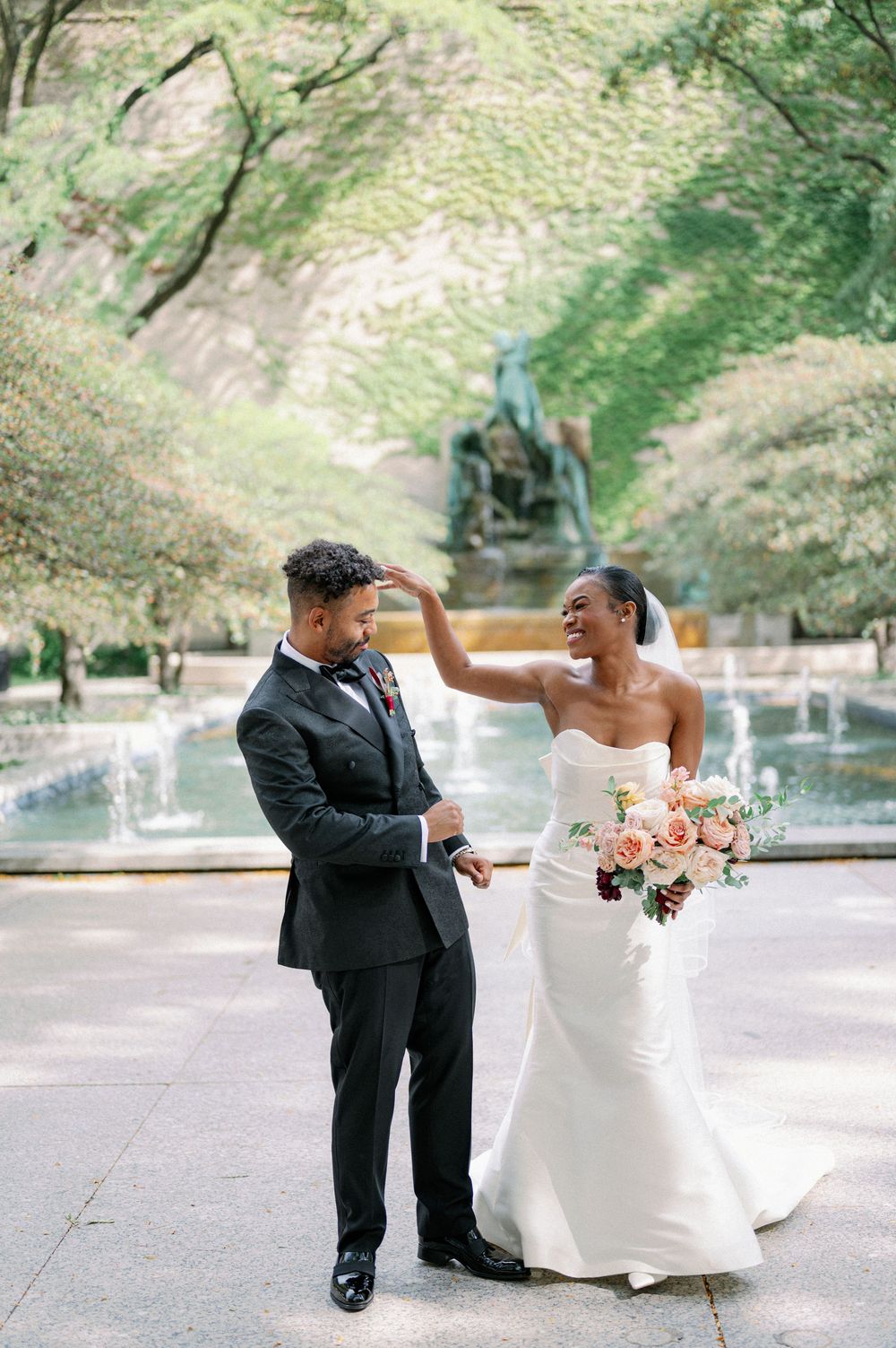 A joyful couple shares a playful moment during their wedding photoshoot in a scenic outdoor setting. - Fairlie Chicago Wedding