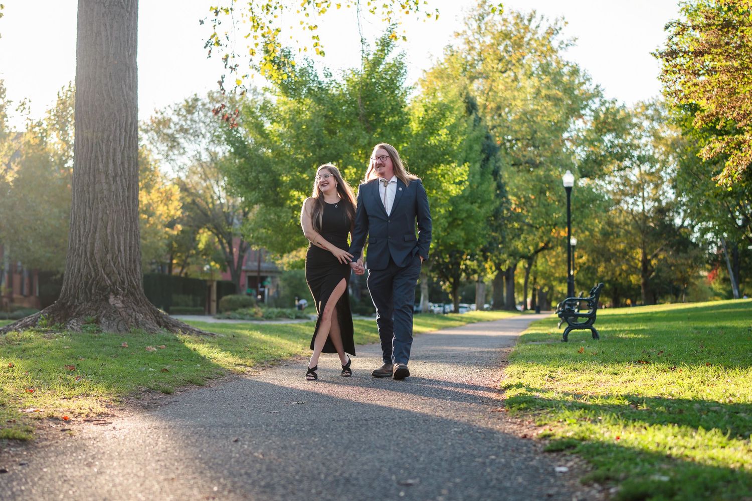 A couple shares a playful embrace in a golden autumn field during a lifestyle photoshoot.